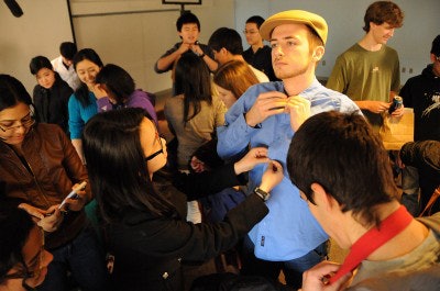 Michelle Chen (left) helps dress Jay McKenna during a “Dress for Success” class at MIT’s 2012 Charm School. (Photo by Holly Hinman)