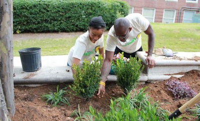 CAU students Regina Newkirk and Henry Wiggins plant flowers during a community service project during homecoming week. (Photo credit: Clark Atlanta University)