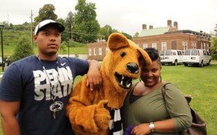 Michael Phelps Jr., 18, and his mother, April Bumbrey, are welcomed at Penn State Schuylkill by the mascot, the Nittany Lion.