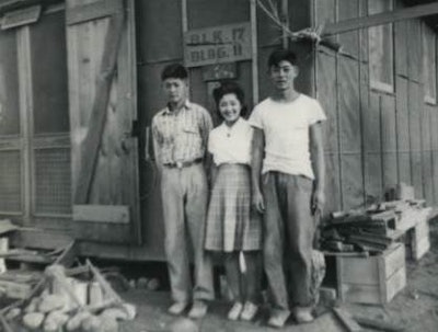 Japanese Americans outside of one of the structures at an internment camp during World War II. (Photo courtesy of California State University Japanese American Digitization Project)