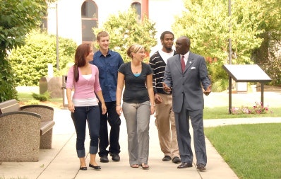 Becker College President Robert E. Johnson, far right, walks with students on campus. (Photo courtesy of Becker College)