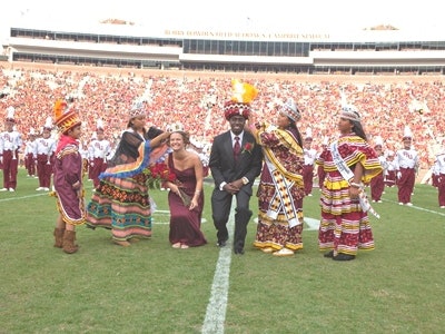 Tribal members crown the homecoming chief and princess with authentic Seminole regalia at Florida State University.