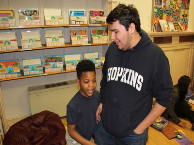 Matthew Rios, a freshman neuroscience and psychology major from Long Beach, California, is helping Malik with multiplying two-digit numbers.