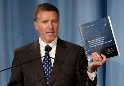 Kenneth Wainstein, a former federal prosecutor holds up the report on UNC-Chapel Hill’s academic problems in association with the athletics department during a news conference at Chapel Hill, NC, Wednesday, Oct. 22, 2014.