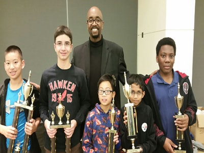 Tony Dunlap, director of the Cleveland chapter of Alpha Phi Alpha Fraternity, Inc., with some previous winners of the Cleveland Scholastic Open chess tournament.