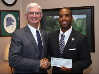 Sean Sheppard (right) receiving a donation from San Diego County Sheriff Bill Gore.