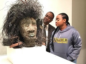 VP of Facility Planning and Management, Marion B. Bracy and his daughter Jasmyne E. Bracy, a senior Communications major, check out artist Allison Saar’s Coiffed at the 2018 exhibition Queen: From the Collection of CCH Pounder at the Xavier University Art Gallery.