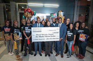 Howard University president Dr. Wayne A. I. Frederick accepts a check totaling $100,000 from members of the Alfred Street Baptist Church.