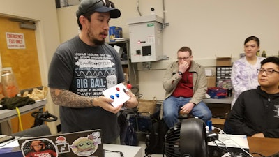 Nate Tilton, far left, holds up a low-cost accessible gaming controller made at the lab.