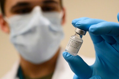 Army Spc. Angel Laureano holds a vial of the COVID-19 vaccine, Walter Reed National Military Medical Center, Bethesda, Md., Dec. 14, 2020.