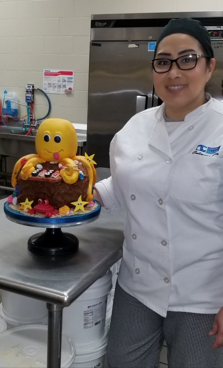 Stephanie Franco stands at Odessa College Baking Level Certificate next to her final project.