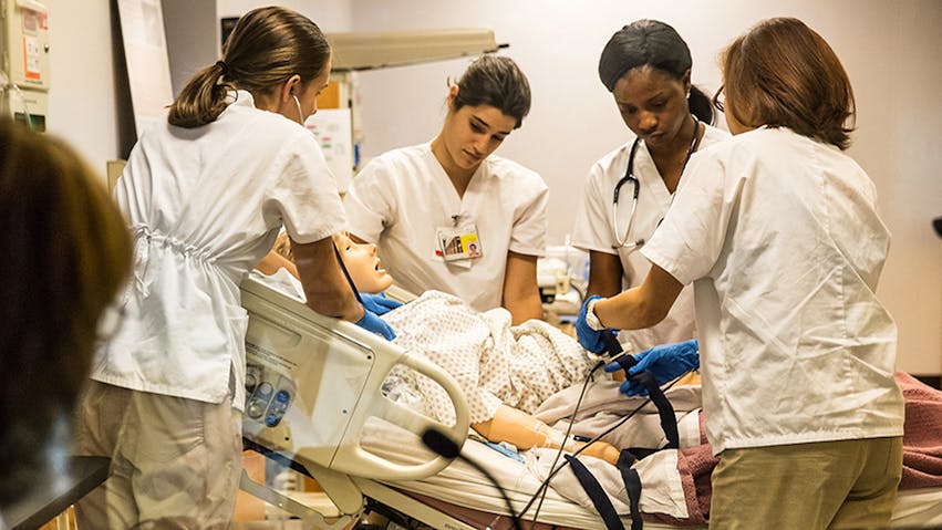 Students train with a nursing mannequin at the University of Maryland School of Nursing.