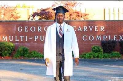 Jelani Day, wearing his white lab coat after graduating from Alabama A&M University.