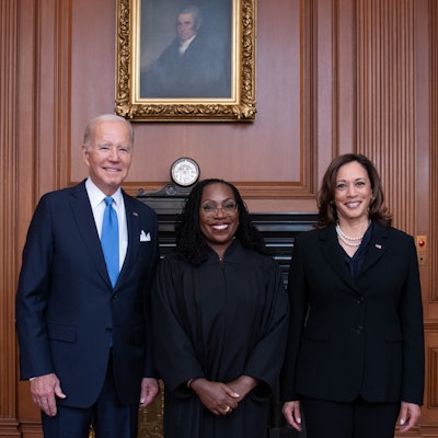 U.S. Supreme Court Justice Ketanji Brown Jackson poses between President Joe Biden and Vice President Kamala Harris.