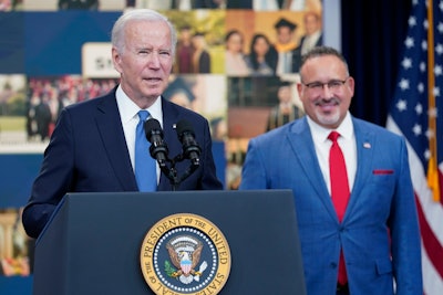U.S. President Joe Biden, left, is flanked by Secretary of Education Dr. Miguel A. Cardona.