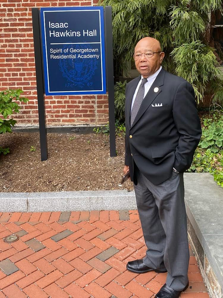 Joseph Stewart standing in front of Isaac Hawkins Hall at Georgetown University, named after his ancestor.