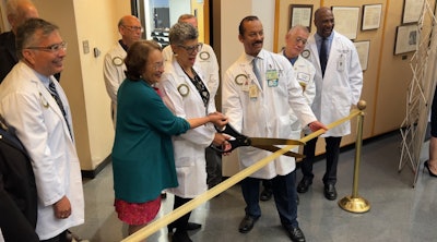 Dr. Arthur Gomez, far left, looks on as Sylvia Drew Ivie, left of center, and other colleagues join Dr. Deborah Prothrow-Stith, founding dean, center, in a ribbon cutting at the opening.