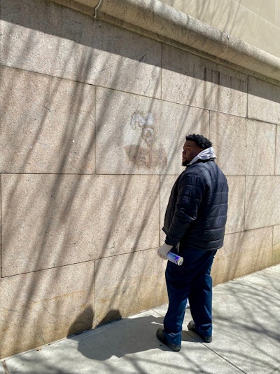 Akeem Luke washes away protest graffiti from the walls of Columbia University.