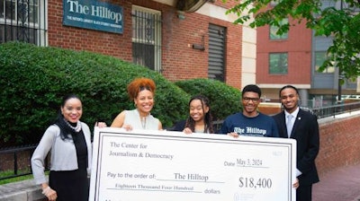 Members of The Hilltop pose with a check from Howard University's Center for Journalism & Democracy, from which fund will go toward technology and staff for the newsroom.